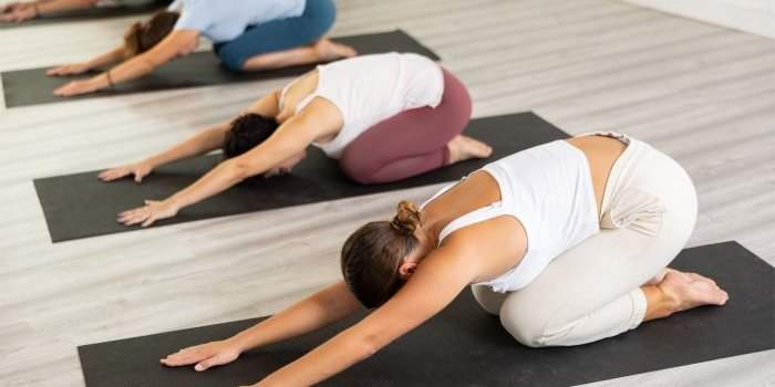 Yoga sur la plage au coucher du soleil